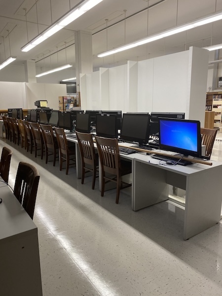 Computer lab with rows of desktop computers on long white tables, wooden chairs, and EverPanel® modular walls.