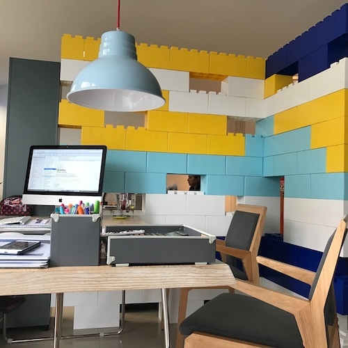 Colorful staggered wall blocks in a office set up with monitor placed on office table